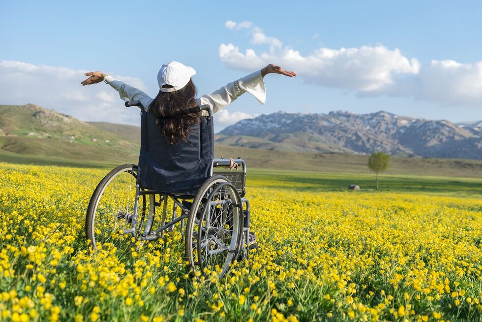 Rollstuhlfahrerin auf einer Blumenwiese