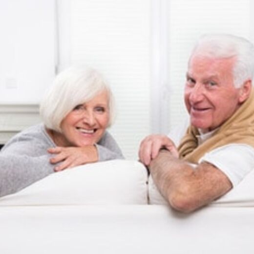 Ältere Mann und Frau sitzen auf einer Couch und schauen nach hinten