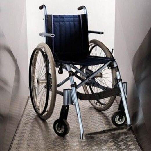 Leerer Rollstuhl auf einer Rollstuhlrampe