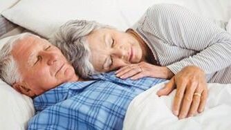 Seniorenpaar liegt glücklich im Bett