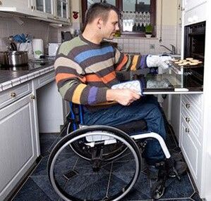 Wohnen mit Behinderung: Ein Rollstuhlfahrer in seiner behindertengerechten Küche