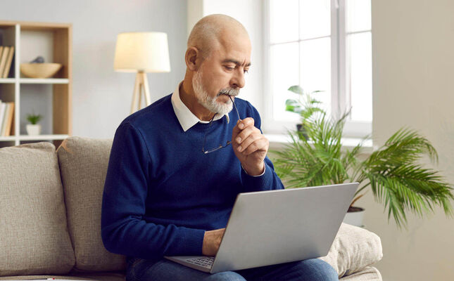 Mann füllt Formular für Vorsorgevollmacht am Laptop aus. © Studio Romantic - stock.adobe.com