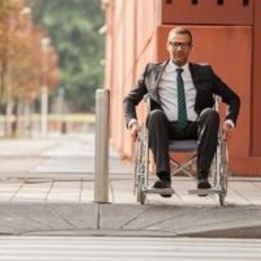 Rollstuhlfahrer fährt in barrierefreier Wohngegend