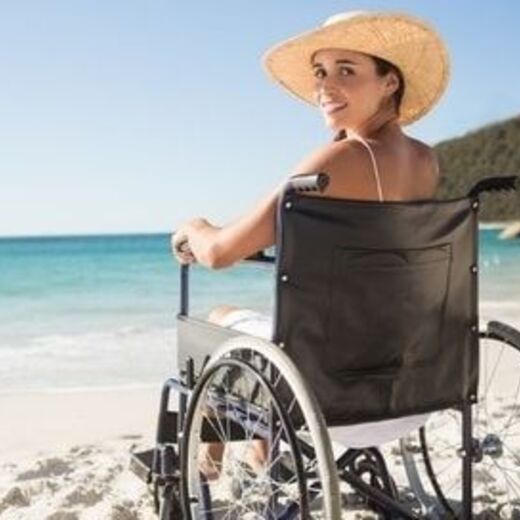 Rollstuhlfahrerin am Strand