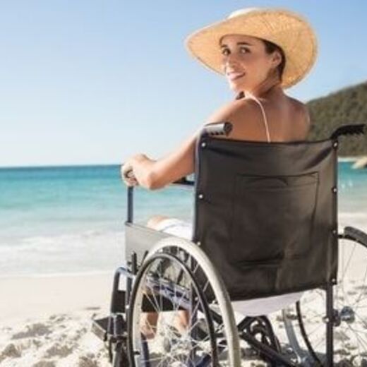 Rollstuhlfahrerin am Strand