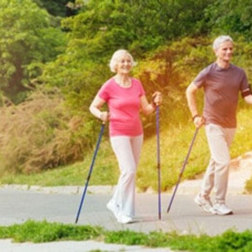 Zwei ältere Personen beim Walking durch den Park