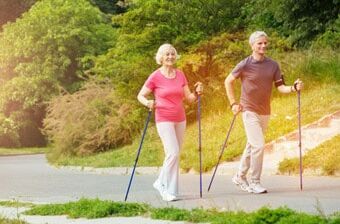 Zwei ältere Personen beim Walking durch den Park