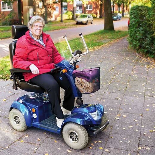 Seniorin sitzt im Elektromobil