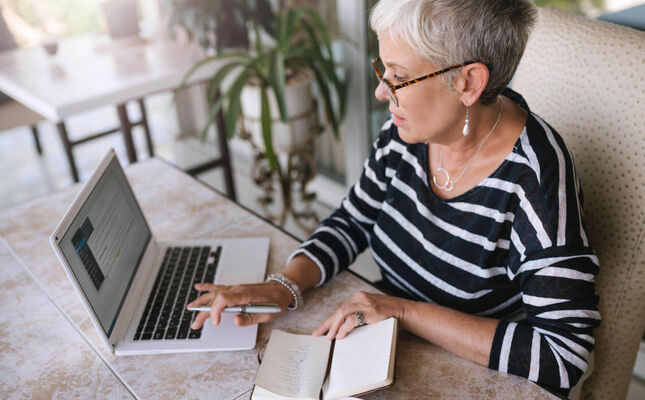 Seniorin am Laptop macht sich Notizen zum Testament. © JonoErasmus - adobe.stock.com