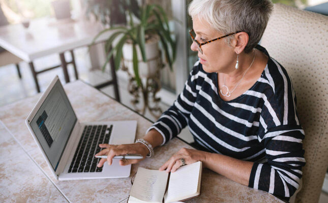Testament schreiben Seniorin am Laptop macht sich Notizen zum Testament. © JonoErasmus - adobe.stock.com