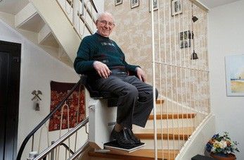 Probefahrt mit einem Treppenlift Senior auf einem Treppenlift