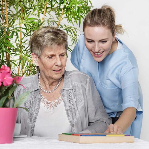 Eine Frau umarmt ihre ältere Mutter