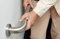 Ältere Person benutzt Geländerstütze