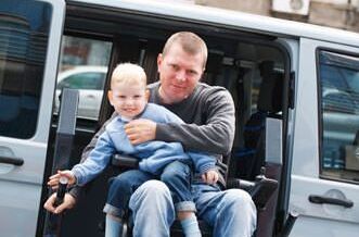 Leben mit Behinderung: Mann mit Sohn im Auto