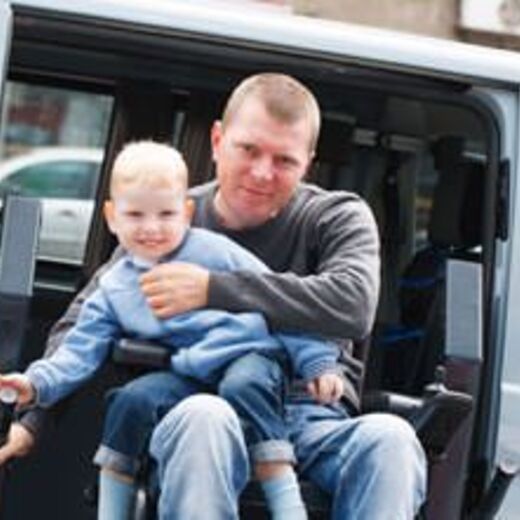 Leben mit Behinderung: Mann mit Sohn im Auto