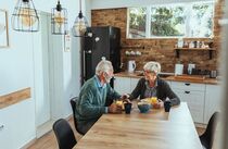 Paar sitzt in ihrer barrierefreien Küche am Frühstückstisch