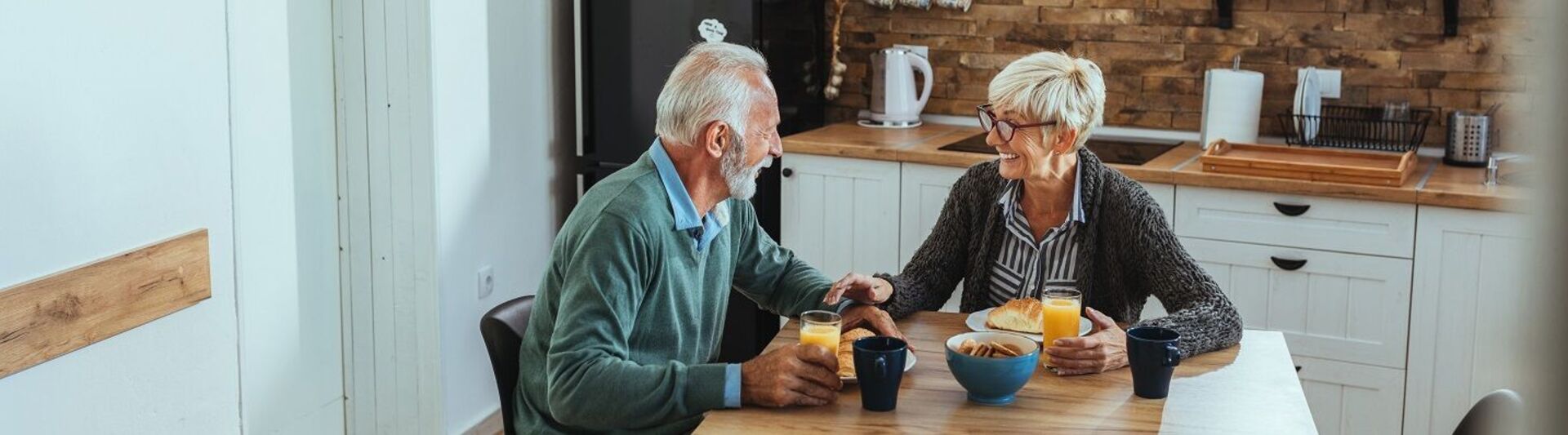 Barrierefreie Küche Paar sitzt in ihrer barrierefreien Küche am Frühstückstisch