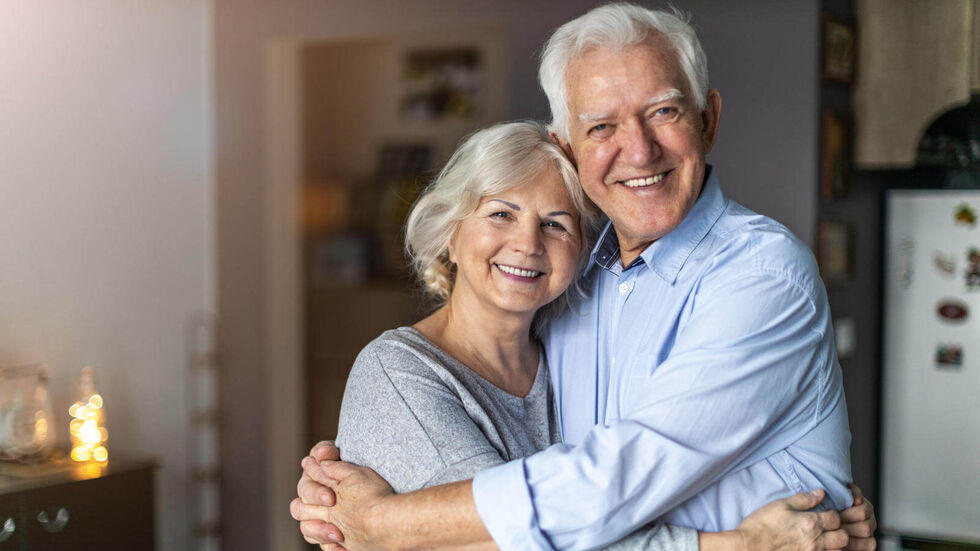 Seniorenpaar umarmt sich in der Küche. © pikselstock - stock.adobe.com