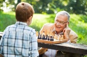 Ein Mann und ein Kind spielen Schach im Freien
