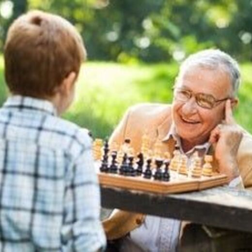 Ein Mann und ein Kind spielen Schach im Freien