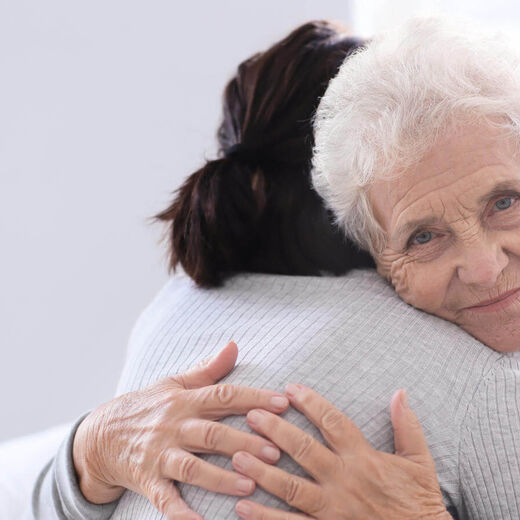 Seniorin umarmt ihre Tochter