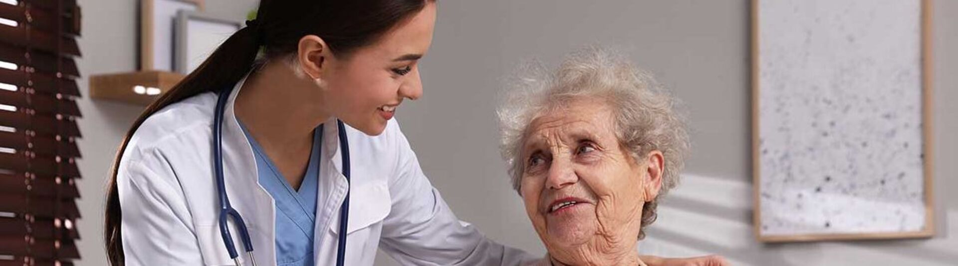 Pflegerin reicht einem Patienten Essen