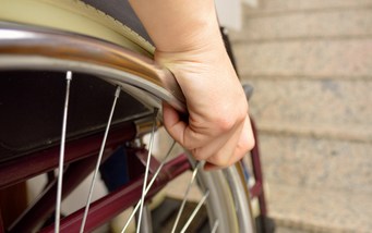 Utilisateurs de fauteuils roulants devant les escaliers sans ascenseur pour fauteuils roulants