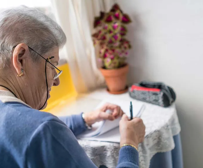 Was Sie über die FINGER-Studie wissen sollten FINGER-Studie: Eine Seniorin mit einer roten Schleife um den Zeigefinger