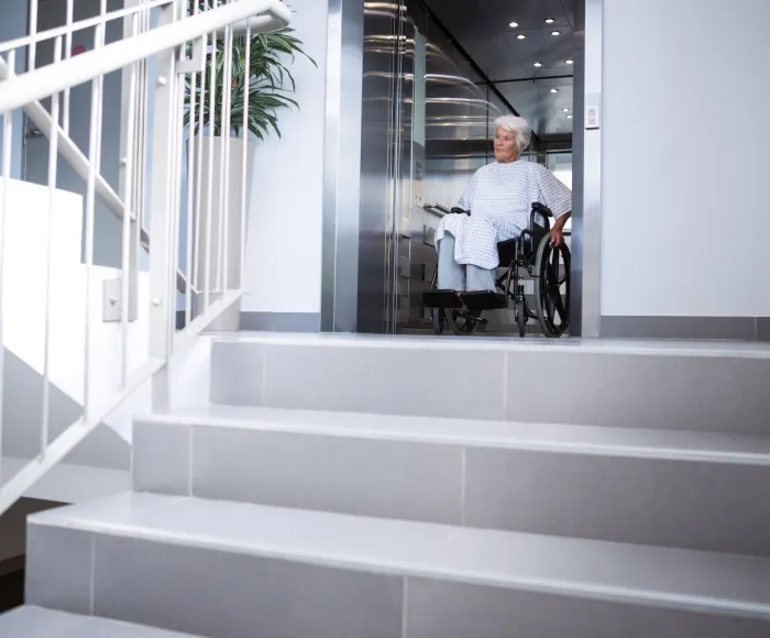 Behindertenlift im Krankenhaus Rollstuhlfahrerin verlässt den Aufzug vom Krankenhaus